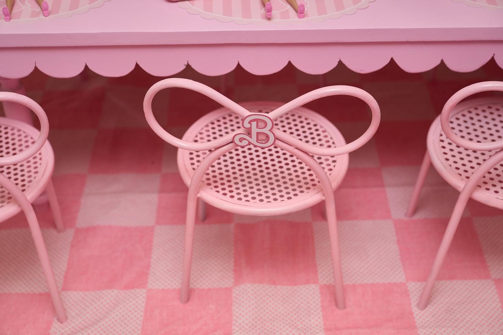 Pink bow chairs on a checkered floor at a children's party