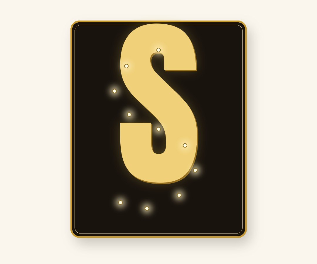 Mini marquee letter example — glowing gold initial S with warm fairy lights on black foam board