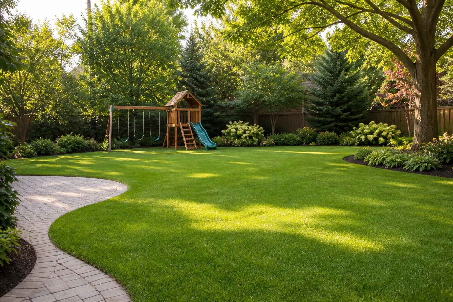 Landscaped family backyard with a large open lawn and wooden swing set in the background